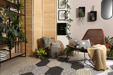Photo of Lounge area interior with comfortable armchair and beautiful houseplants