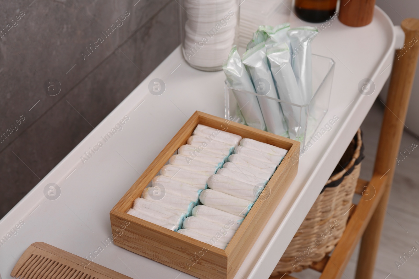 Photo of Many different tampons and personal care products on white table near grey wall, above view