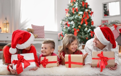 Happy parents with children and gifts at home. Celebrating Christmas