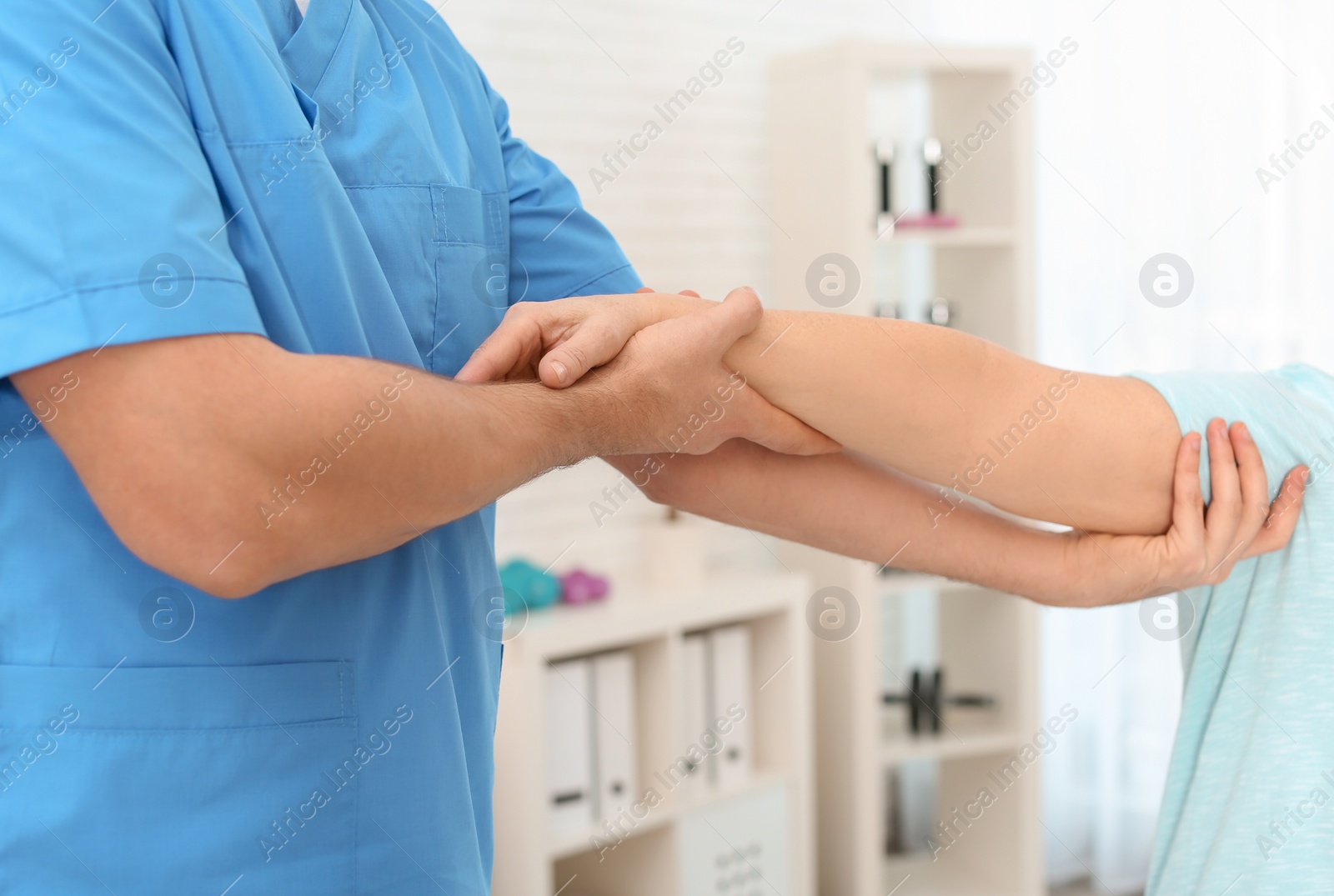 Photo of Physiotherapist working with patient in clinic, closeup. Rehabilitation therapy