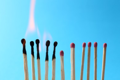 Burning and whole matches on light blue background. Space for text