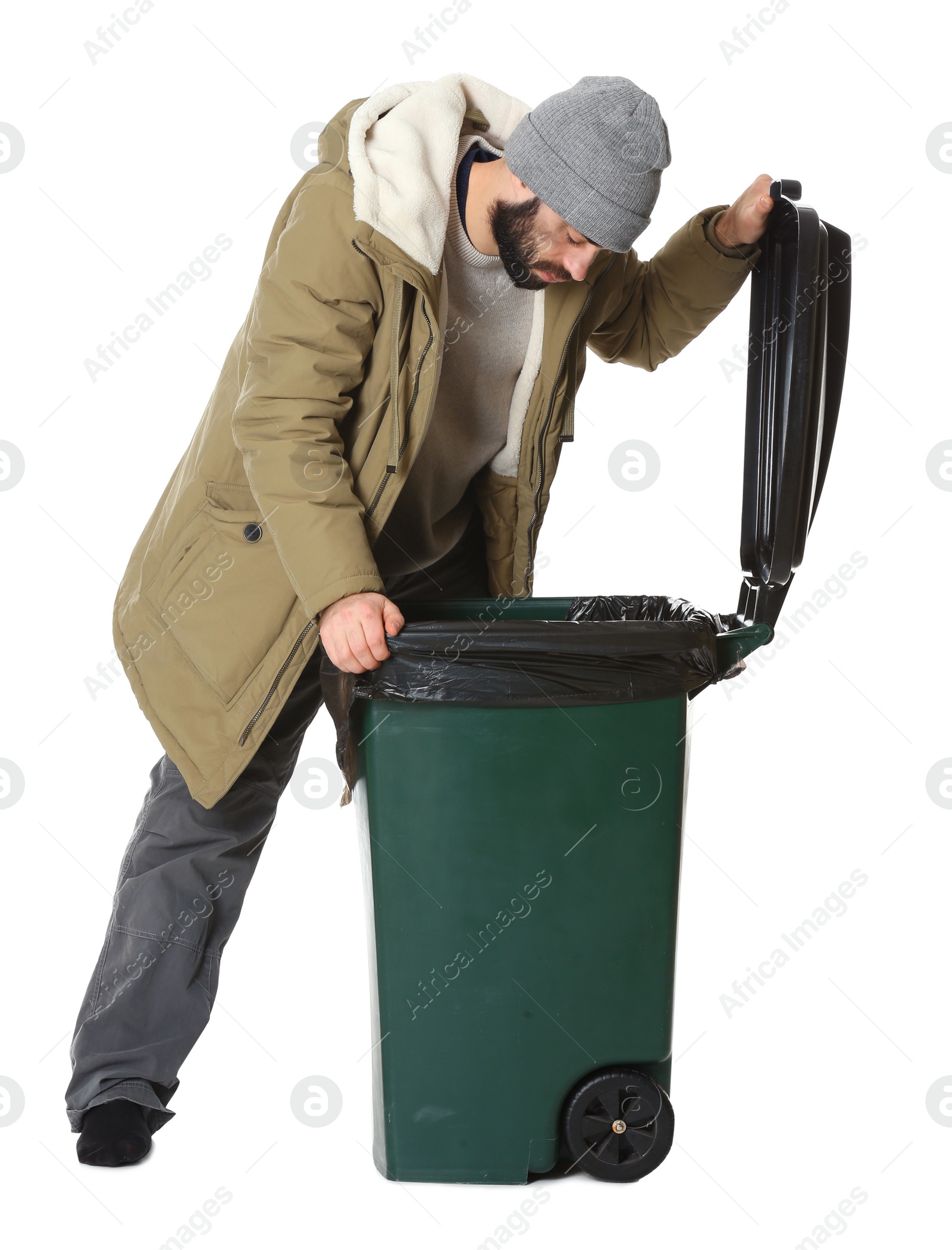 Photo of Poor homeless man digging in trash bin isolated on white