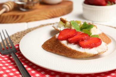 Delicious ricotta bruschettas with strawberry and mint served on table, closeup