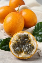 Delicious ripe granadillas on white wooden table, closeup