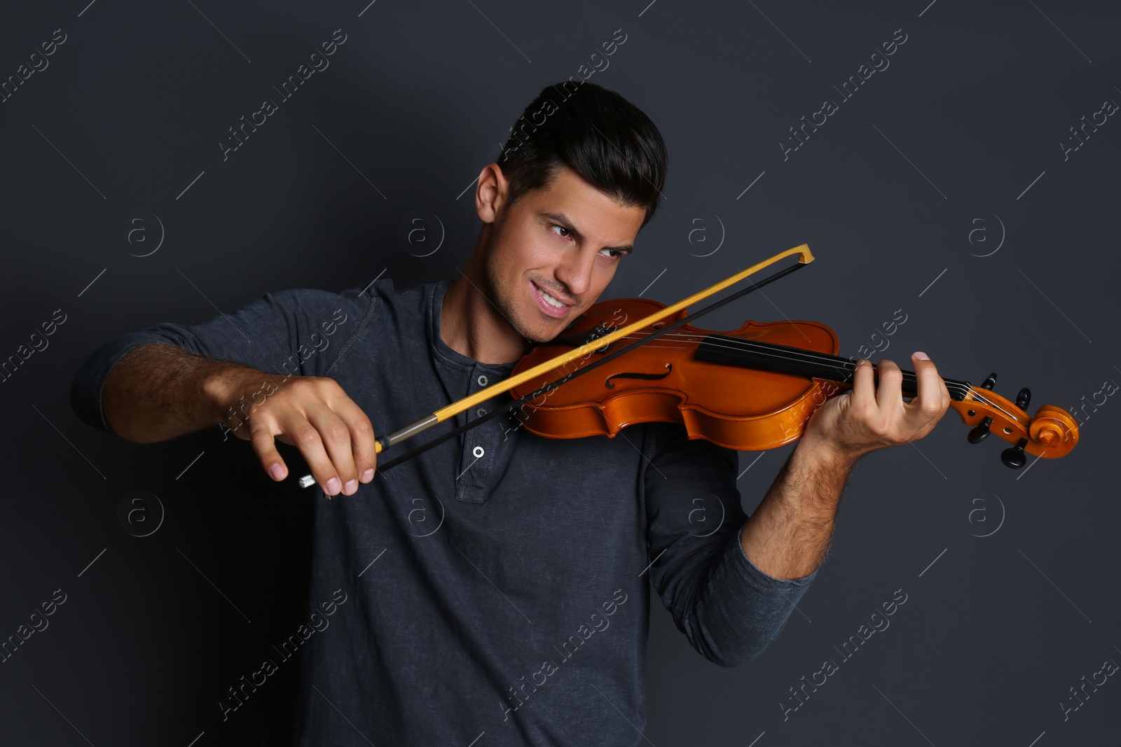 Photo of Happy man playing violin on black background