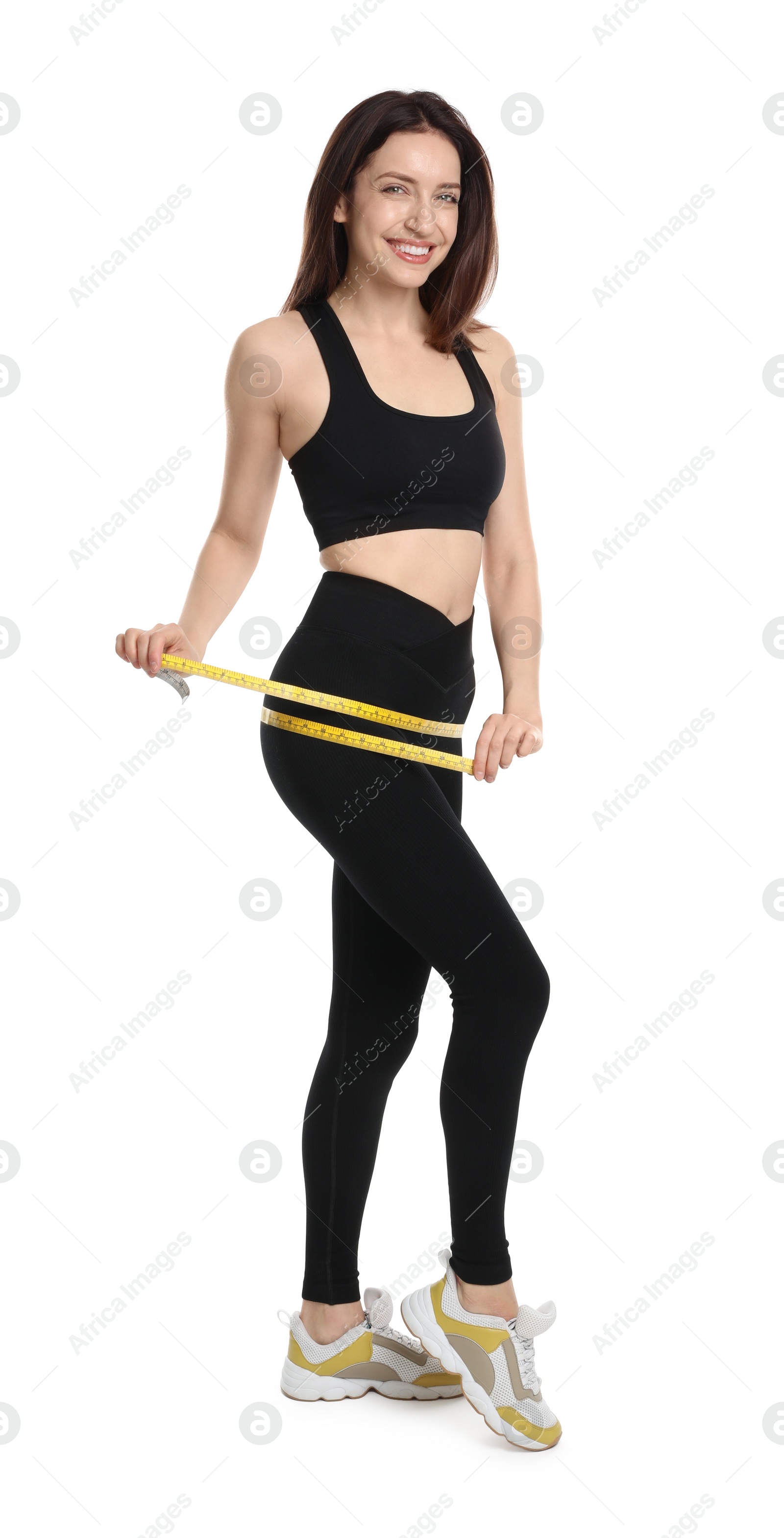 Photo of Happy young woman with measuring tape showing her slim body against white background