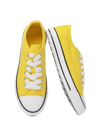 Pair of yellow classic old school sneakers on white background