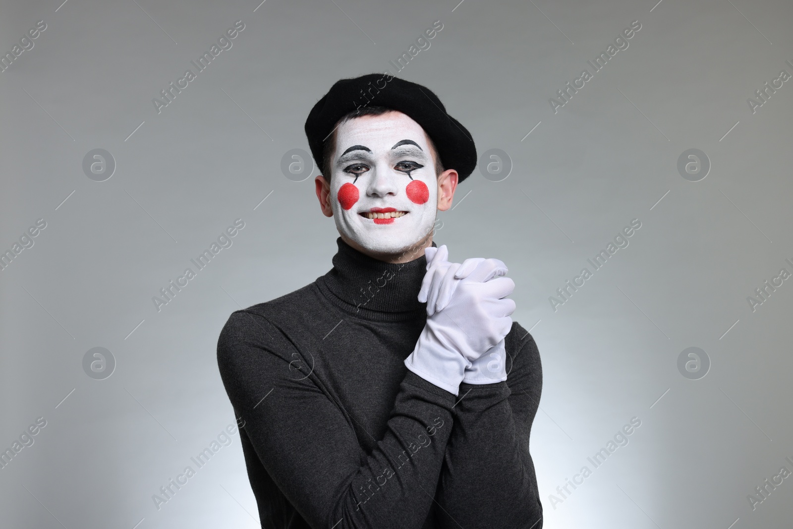 Photo of Portrait of mime artist in beret on grey background