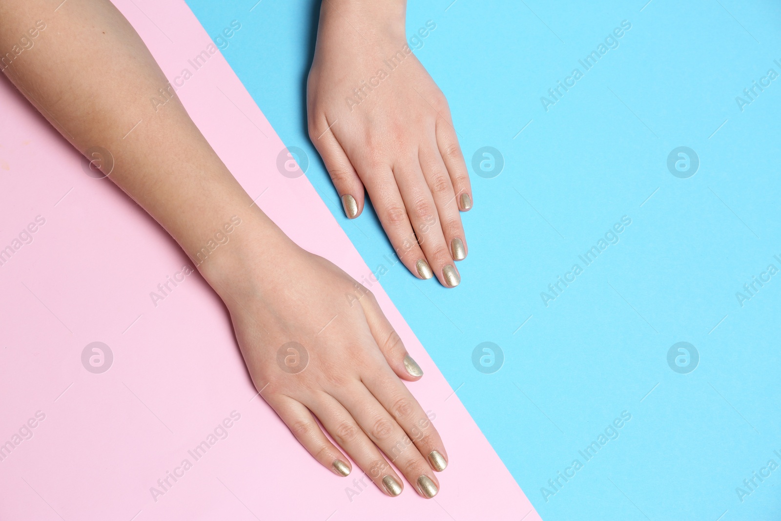 Photo of Woman showing golden manicure on color background, top view with space for text. Nail polish trends