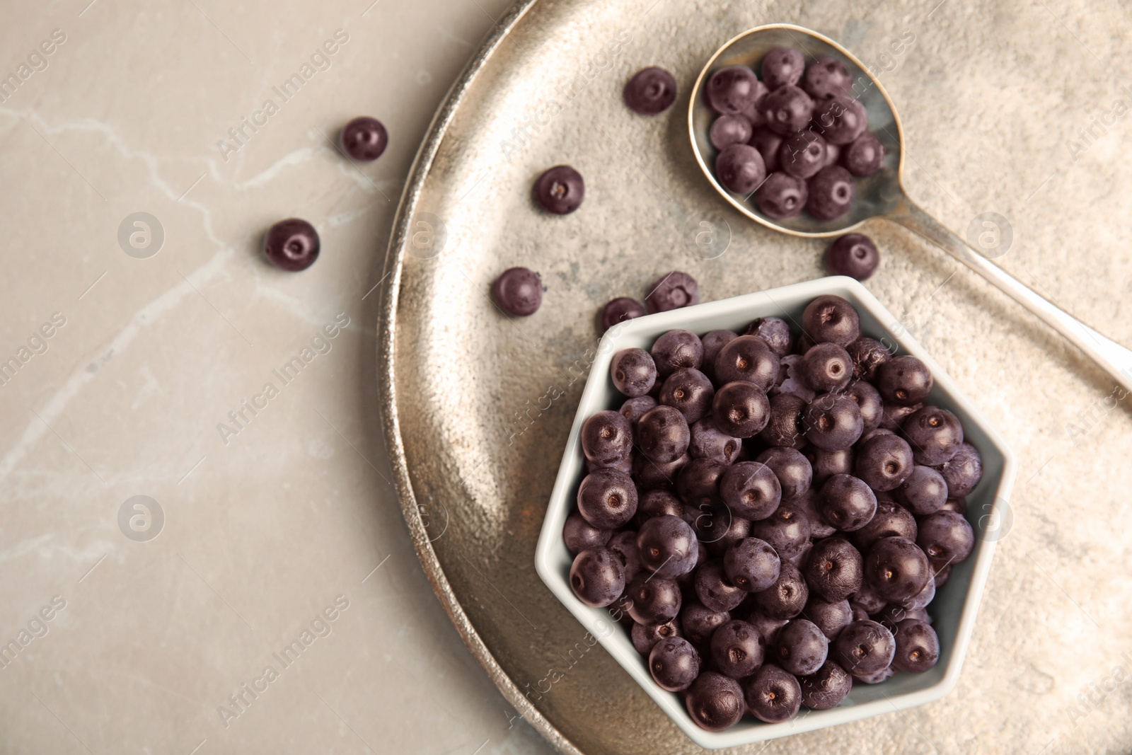 Photo of Bowl with fresh acai berries on tray, top view