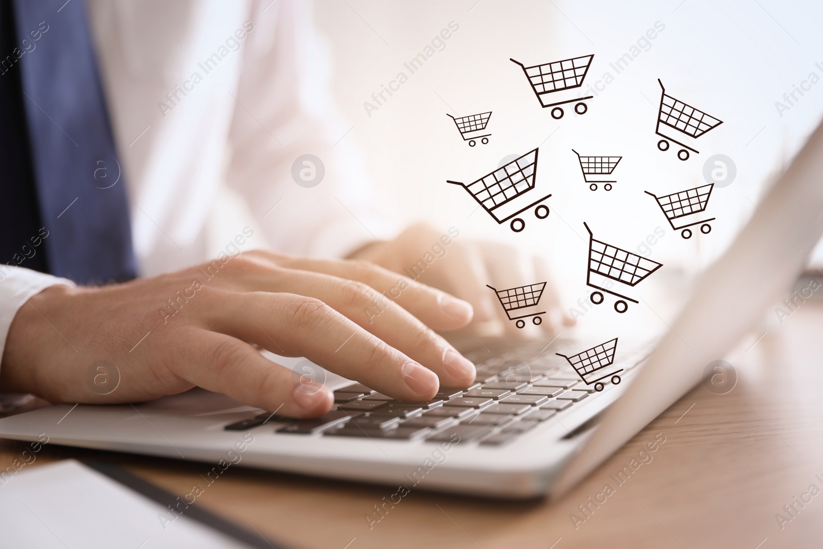 Image of Man using laptop for online shopping at wooden table, closeup