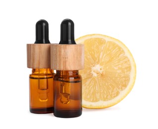 Photo of Bottles of citrus essential oil and fresh lemon isolated on white