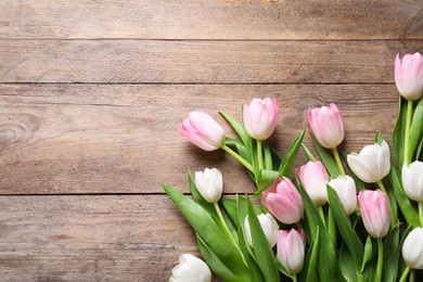 Beautiful pink spring tulips on wooden background, flat lay. Space for text