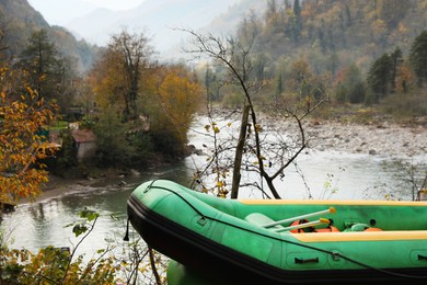 Photo of Inflatable rubber fishing boat near river in mountains