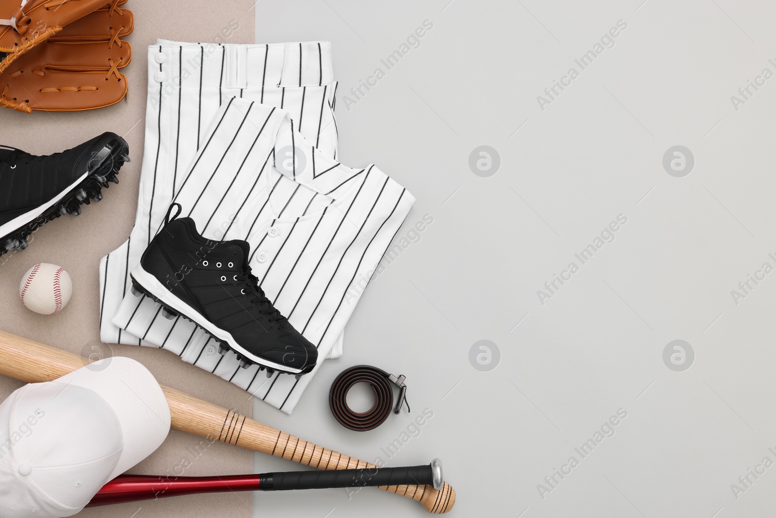 Photo of Flat lay composition with baseball uniform and sports equipment on color background. Space for text