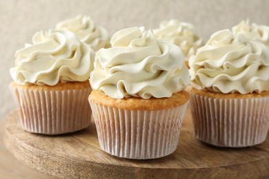 Photo of Tasty vanilla cupcakes with cream on table, closeup
