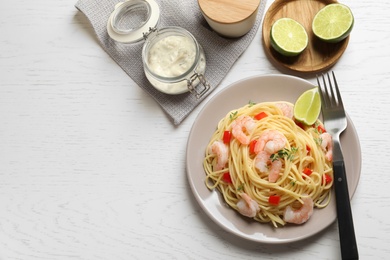 Photo of Plate with spaghetti and shrimps on light background, top view