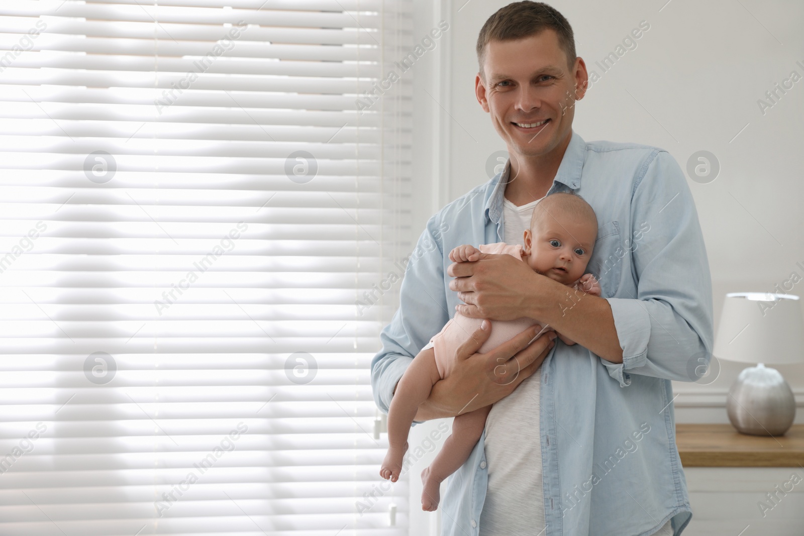 Photo of Happy father holding his cute little baby at home, space for text