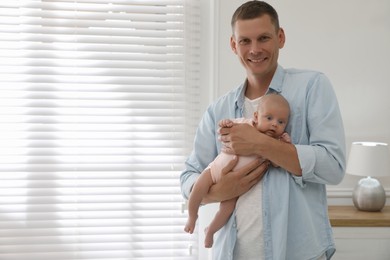 Photo of Happy father holding his cute little baby at home, space for text