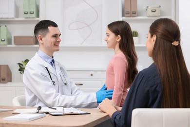 Photo of Gastroenterologist examining girl with stomach ache in clinic