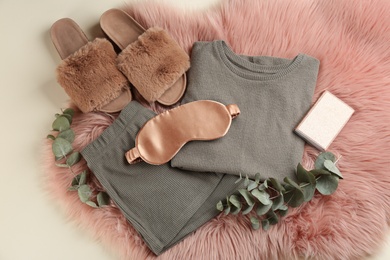 Flat lay composition with house slippers, sleeping mask and pajamas on light background