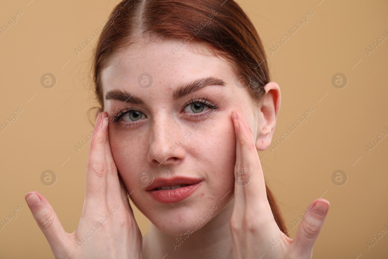 Photo of Portrait of beautiful woman with freckles on beige background, closeup