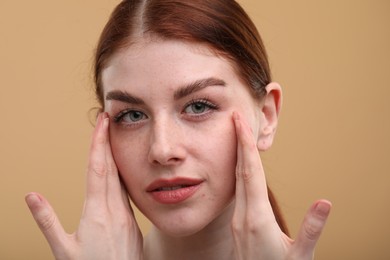 Portrait of beautiful woman with freckles on beige background, closeup