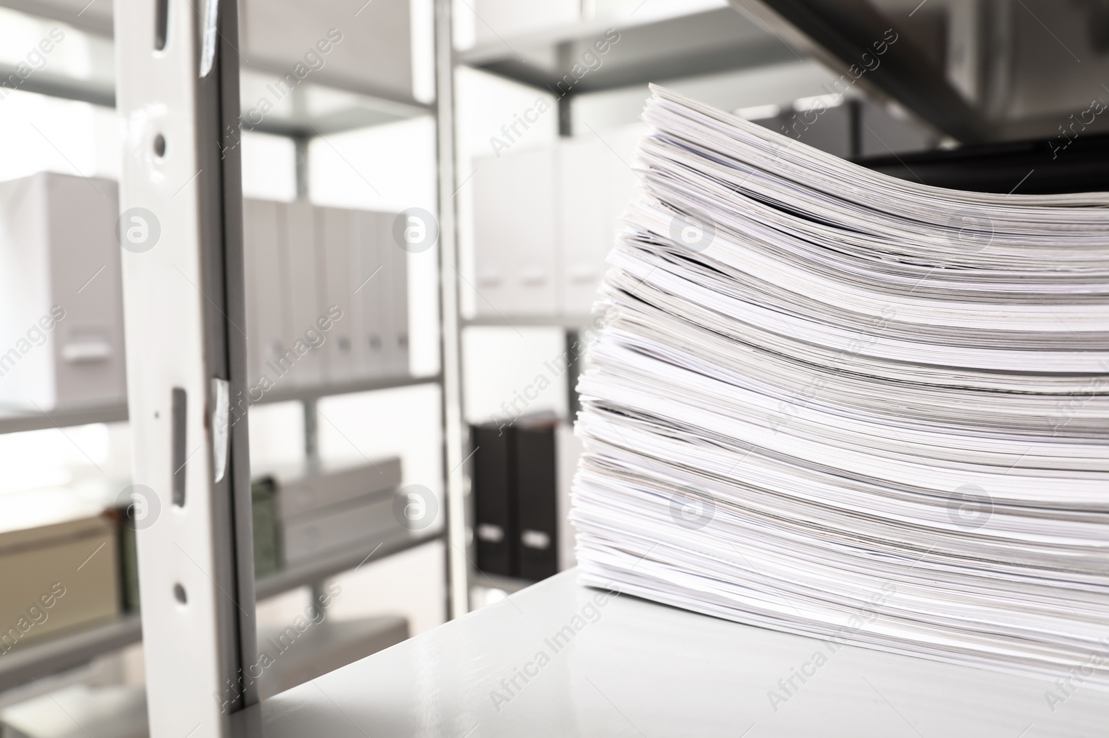 Photo of Stack of documents on shelf in office. Space for text