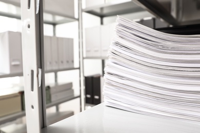 Stack of documents on shelf in office. Space for text