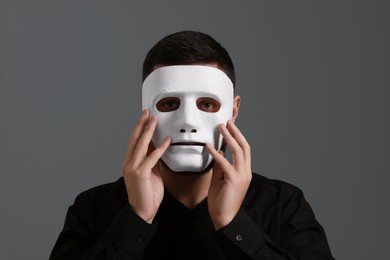 Photo of Multiple personality concept. Man in mask on grey background