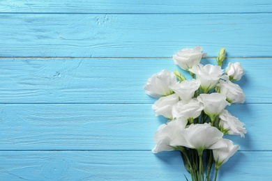 Photo of Flat lay composition with beautiful Eustoma flowers on wooden background