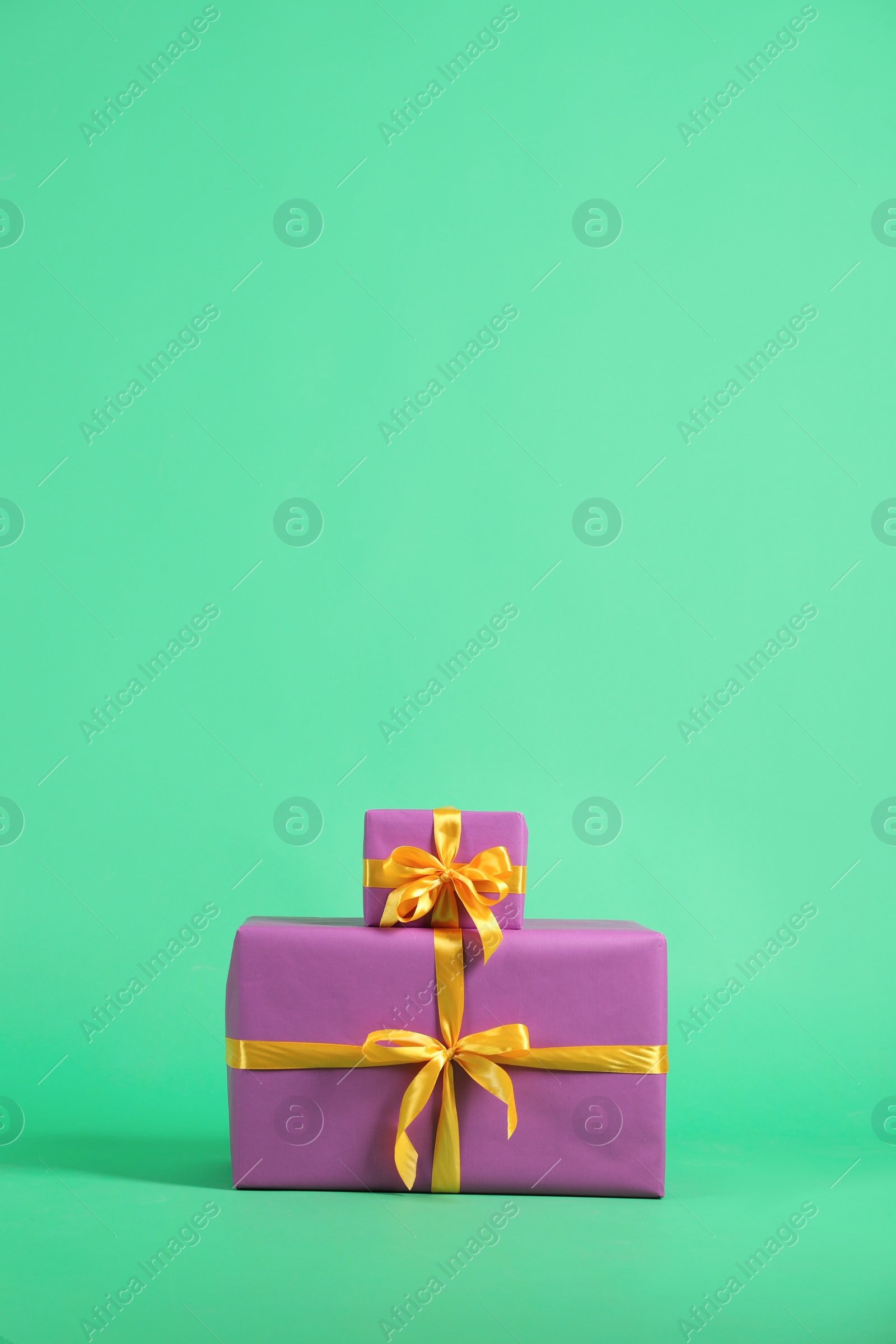 Photo of Beautifully wrapped gift boxes on green background. Space for text