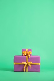 Photo of Beautifully wrapped gift boxes on green background. Space for text