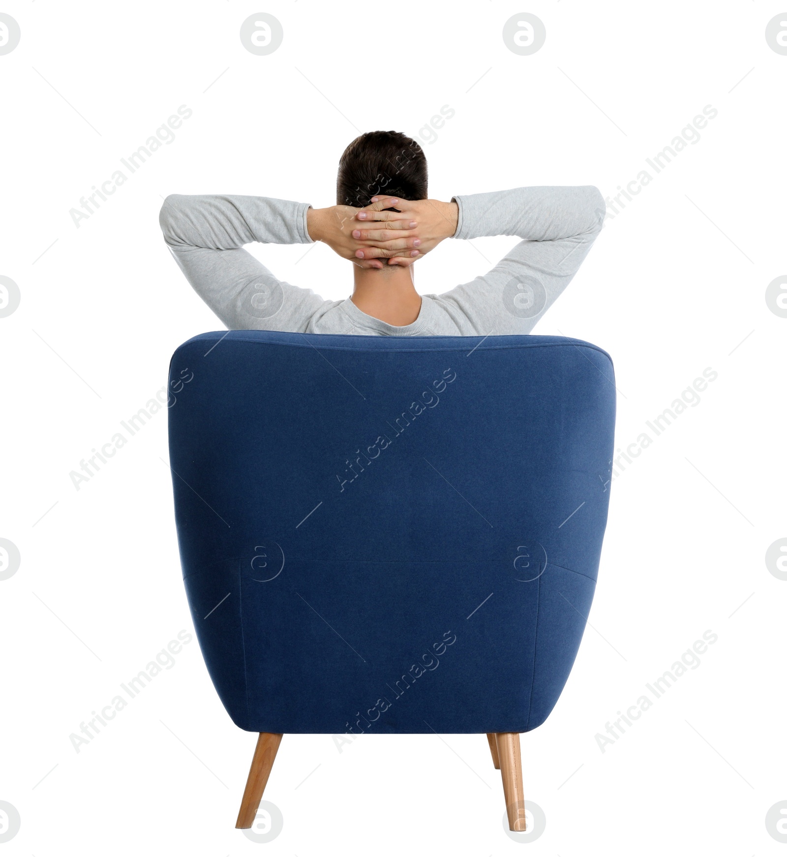 Photo of Young man sitting in armchair on white background, view from back