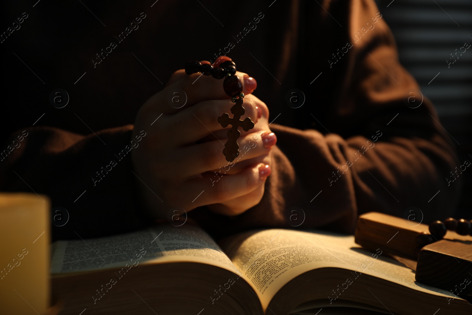 Photo of Woman with Bible praying at table, closeup