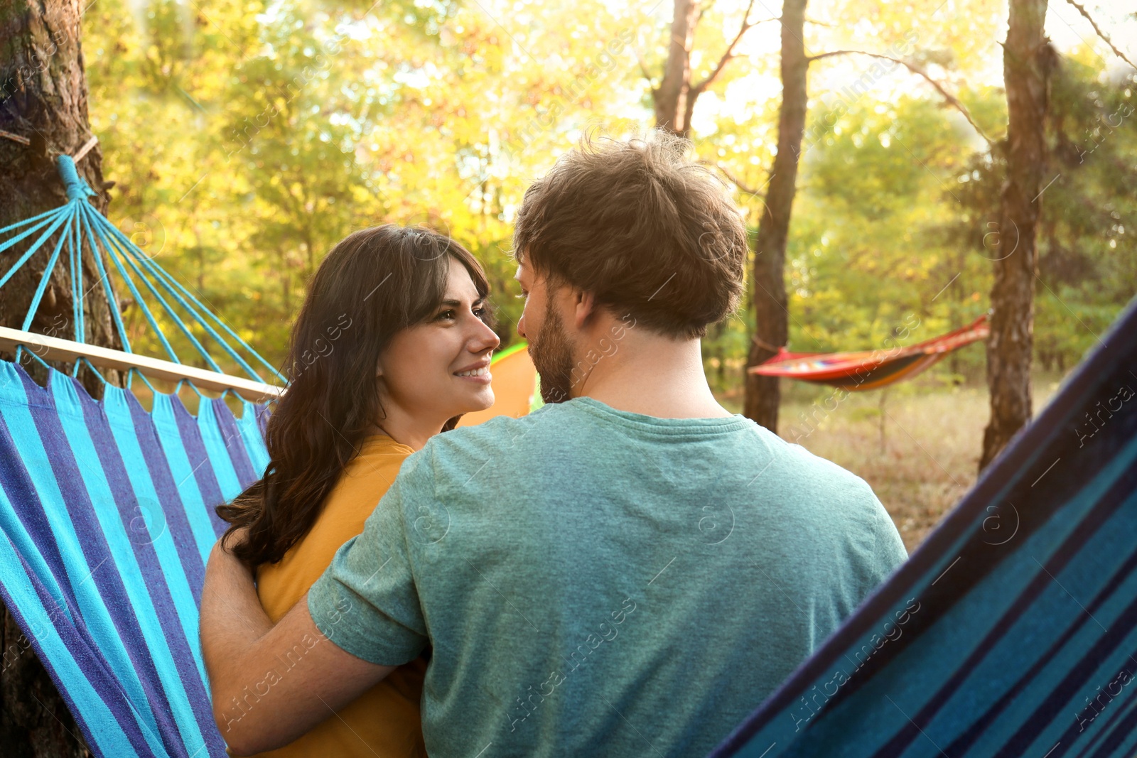 Photo of Lovely couple resting in comfortable hammock outdoors