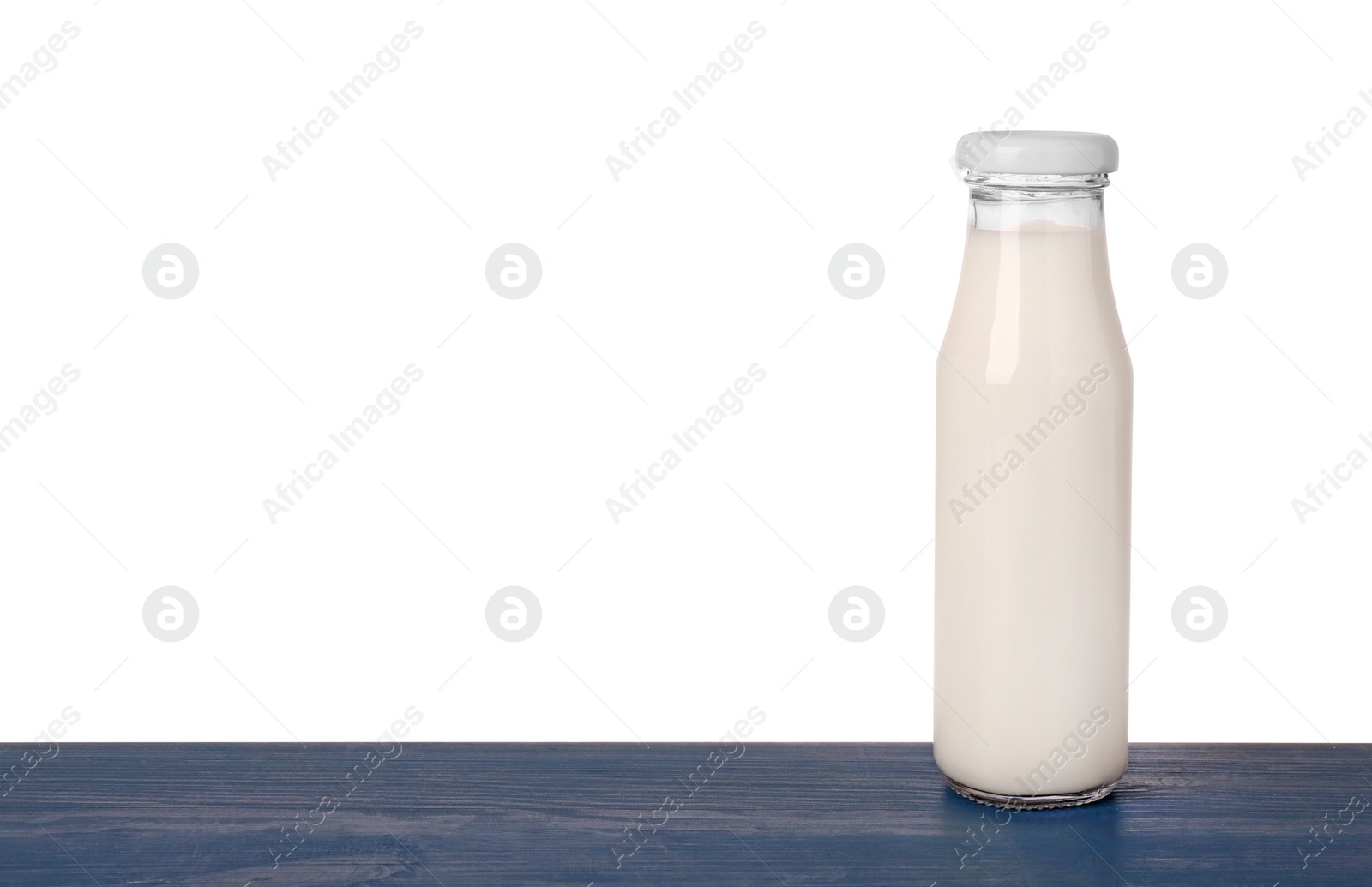 Photo of Bottle with tasty milk on blue wooden table against white background