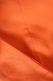 Photo of Texture of orange fabric as background, closeup
