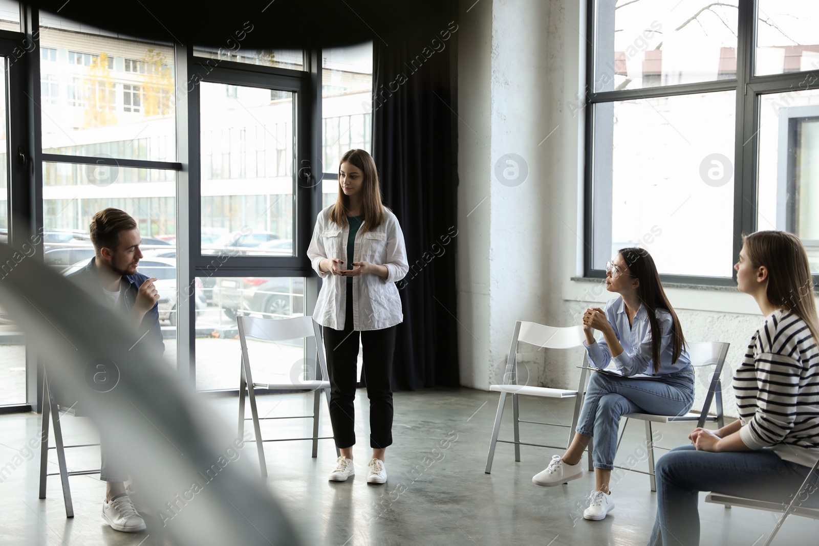 Photo of Psychotherapist working with patients in group therapy session indoors