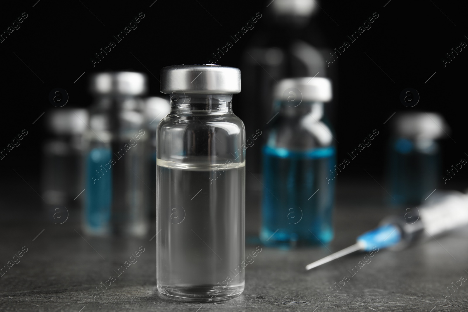 Photo of Vial with medication on grey table. Vaccination and immunization