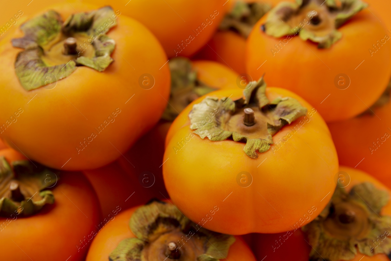 Photo of Delicious ripe juicy persimmons as background, closeup