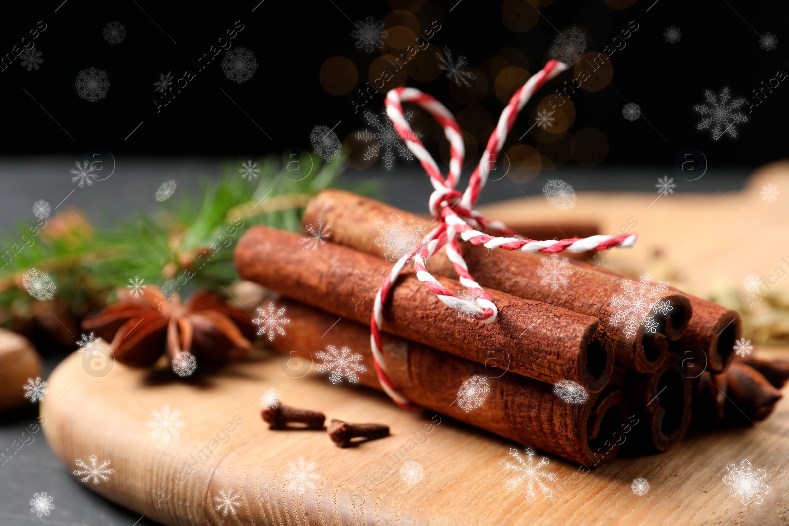 Image of Different spices and fir tree branches on dark table, closeup. Cinnamon, anise, cardamom