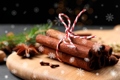 Different spices and fir tree branches on dark table, closeup. Cinnamon, anise, cardamom