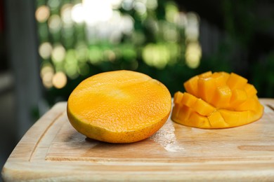 Cut ripe juicy mango on wooden board