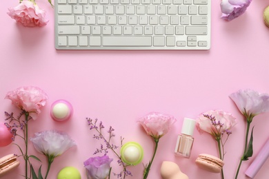 Photo of Flat lay composition with keyboard and flowers on pink background. Beauty blogger's workplace