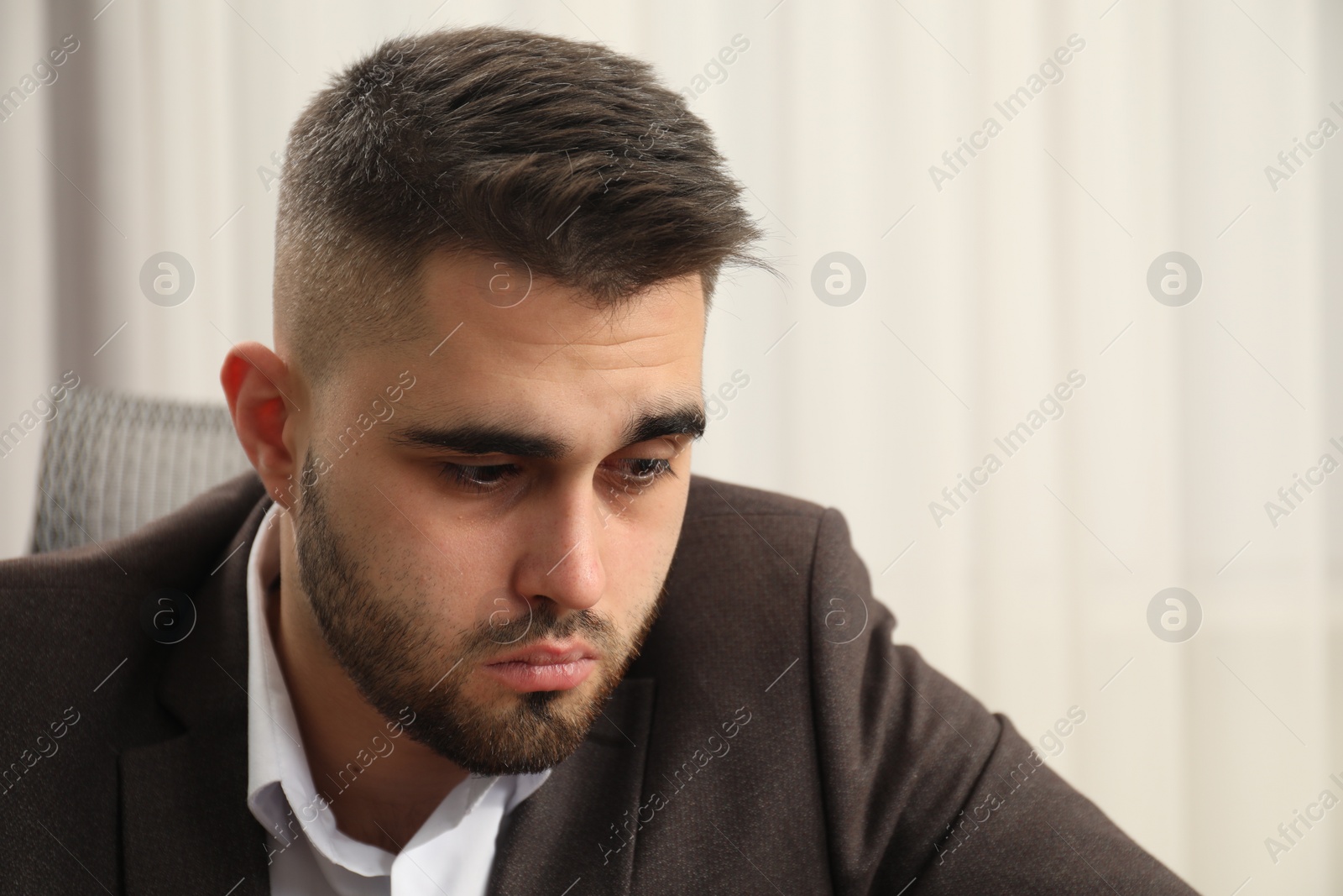 Photo of Portrait of sad businessman on blurred background