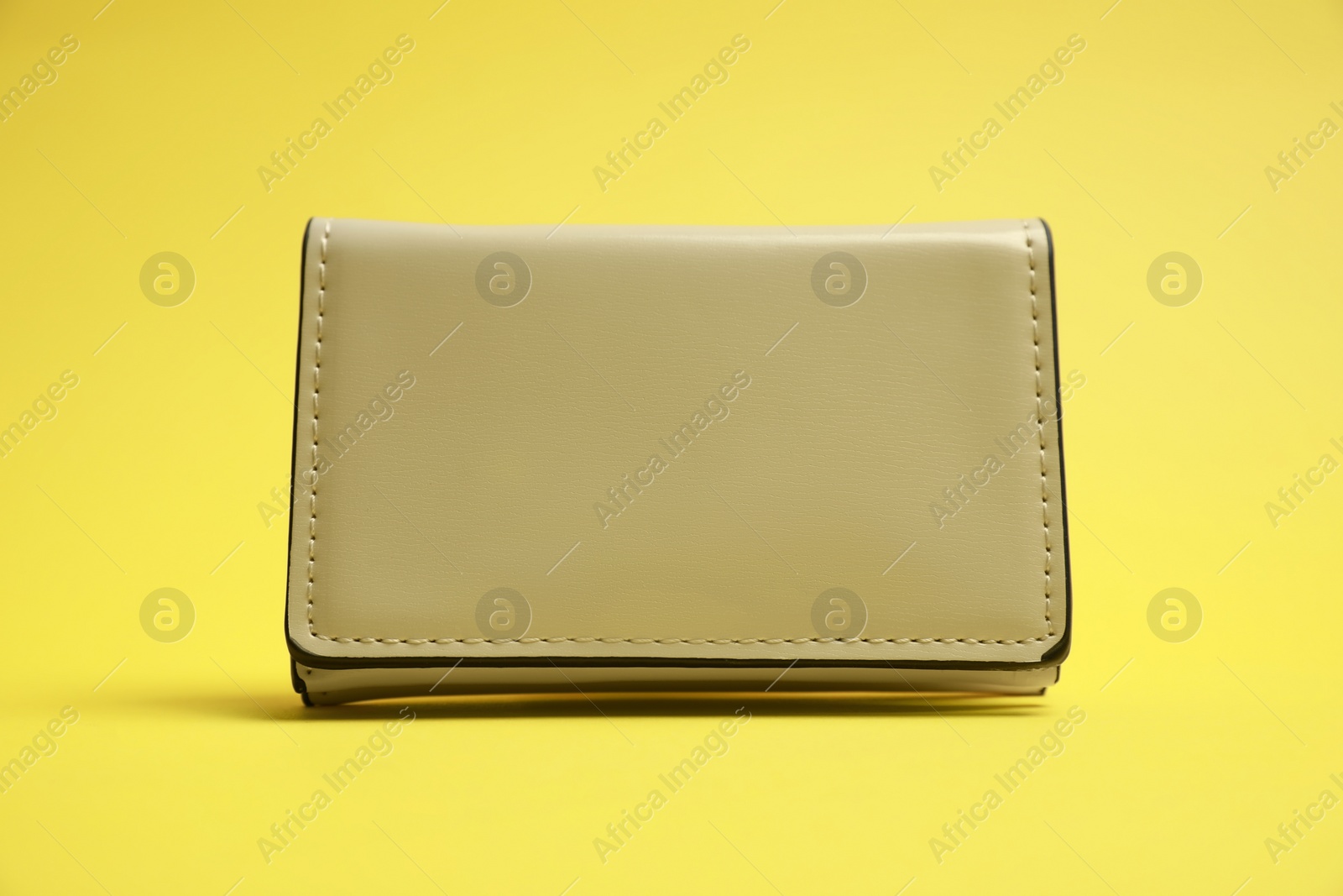 Photo of Stylish white leather purse on yellow background