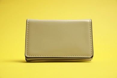 Photo of Stylish white leather purse on yellow background