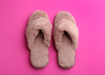 Pair of stylish soft slippers on pink background, flat lay