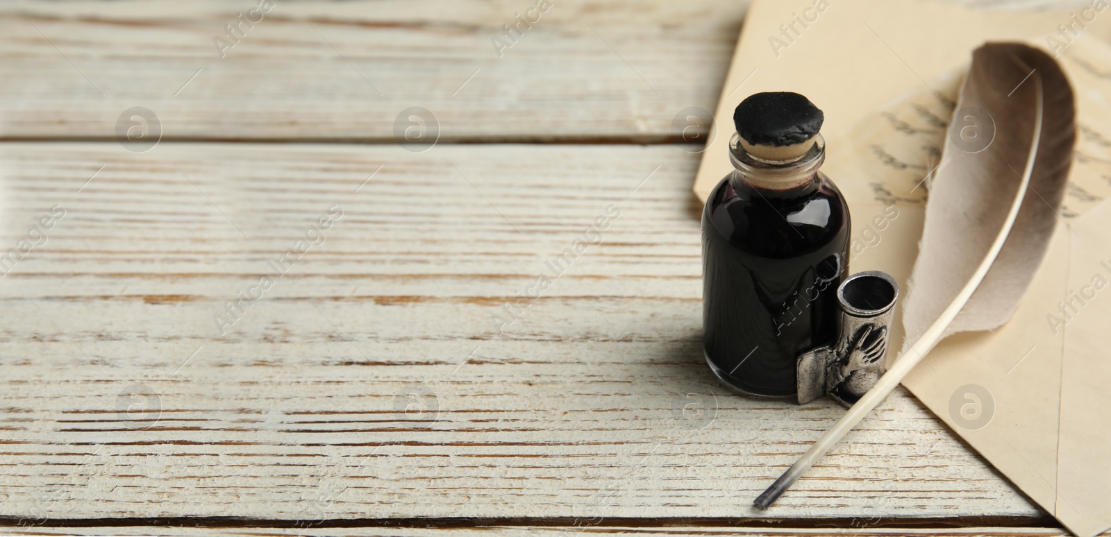 Image of Quill, bottle of ink and letter on white wooden table, space for text. Banner design